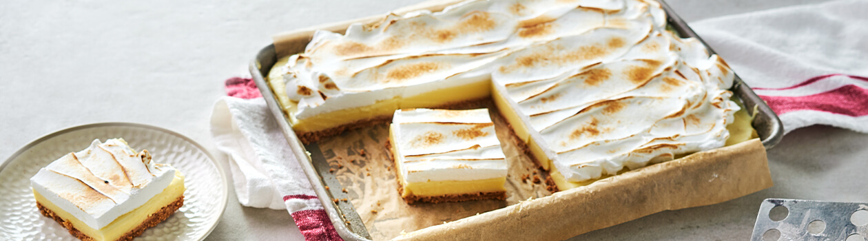 Flapper pie in a baking tin with three slices cut out from it.